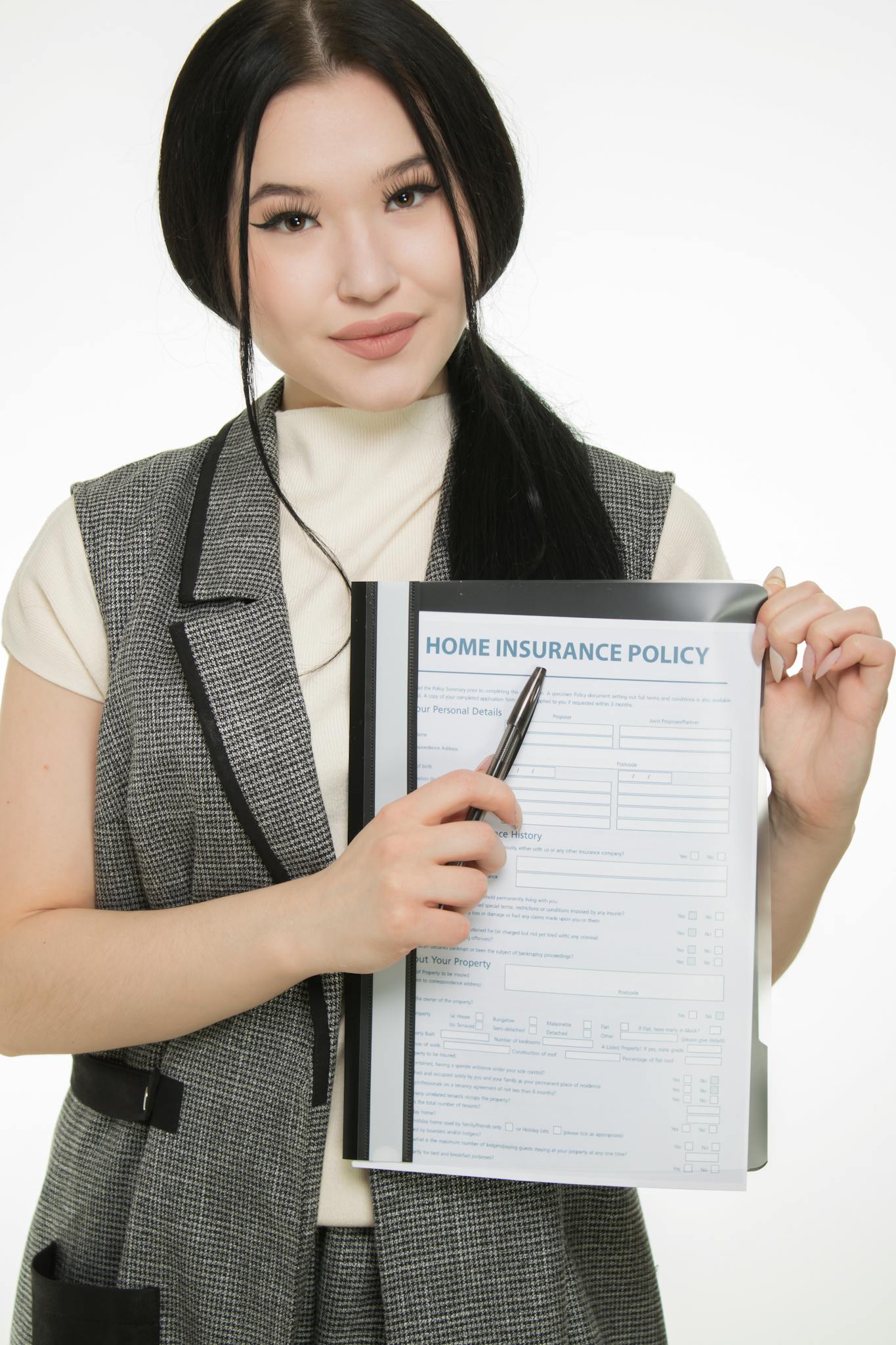 Young woman presenting a home insurance policy document while pointing with a pen.